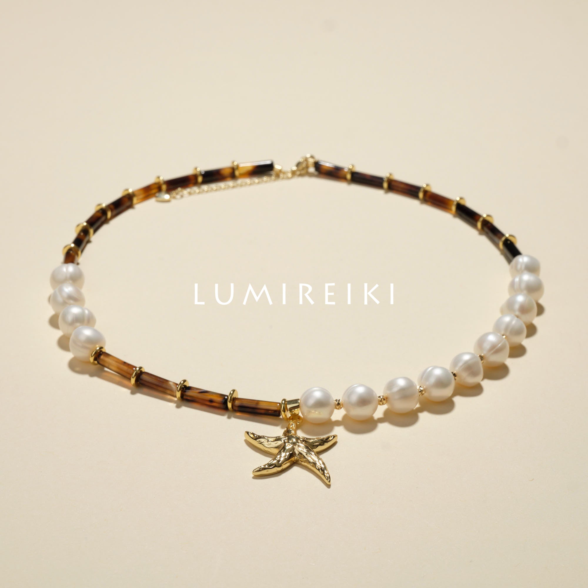 Pearl Tranquil Necklace featuring 10-11mm pearls and 4x13mm cylinders with a gold starfish charm for elegance and calm.